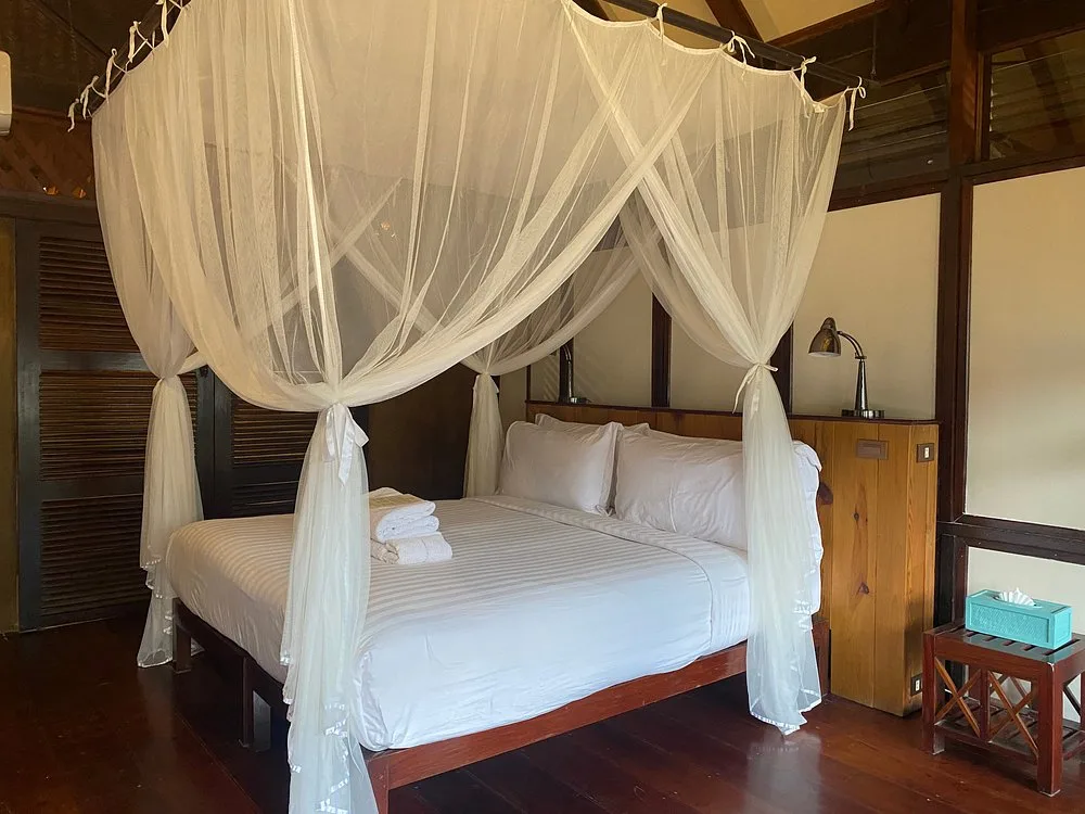 Double bed under a mosquito net in a Luang Say Lodge bungalow